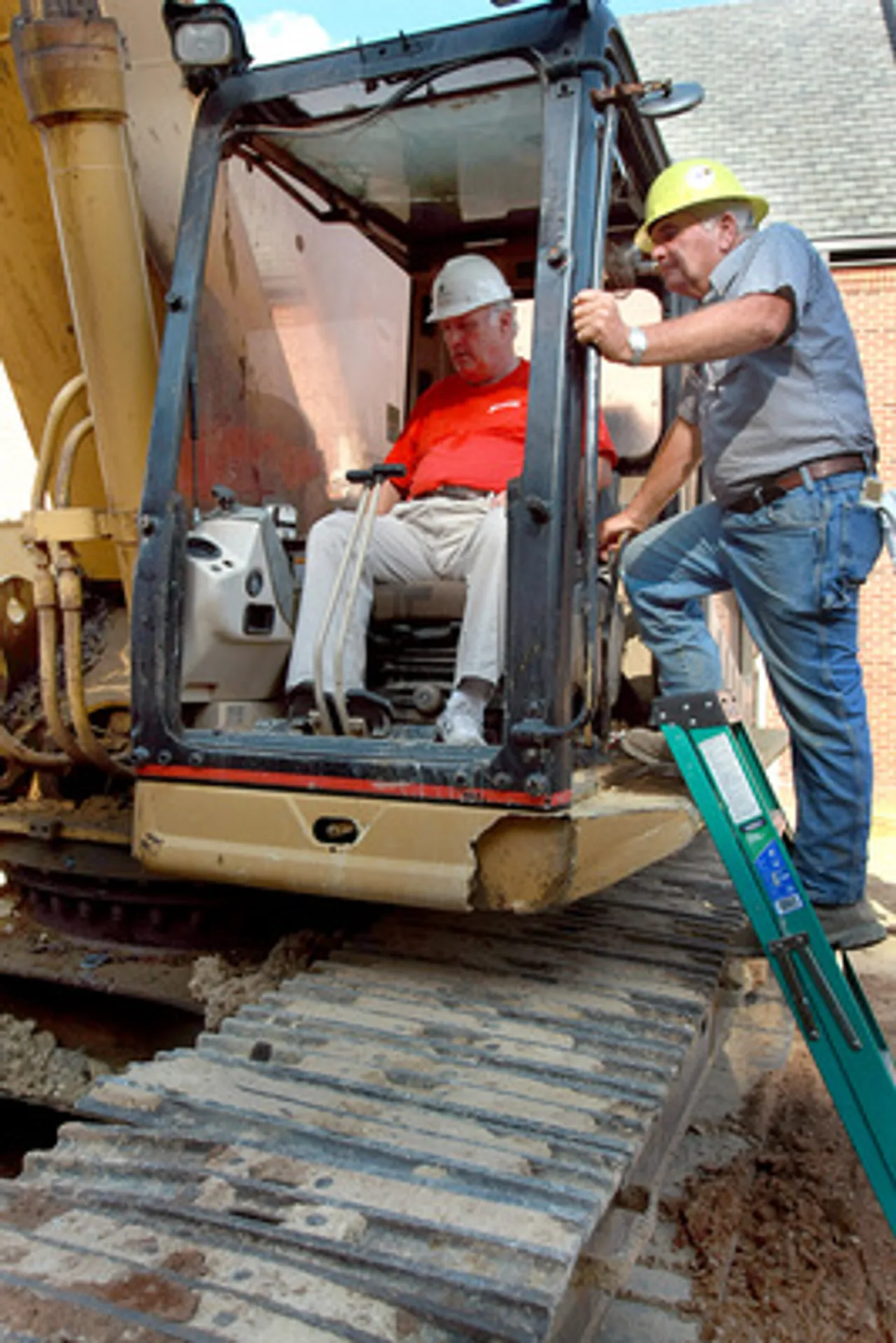 DarMid061509a; Darlington Middle School Director Jim Van Es gets directions on how to operate the shovel bucket from Buddy Couch of Evans Construction. Ken Caruthers/RN-T