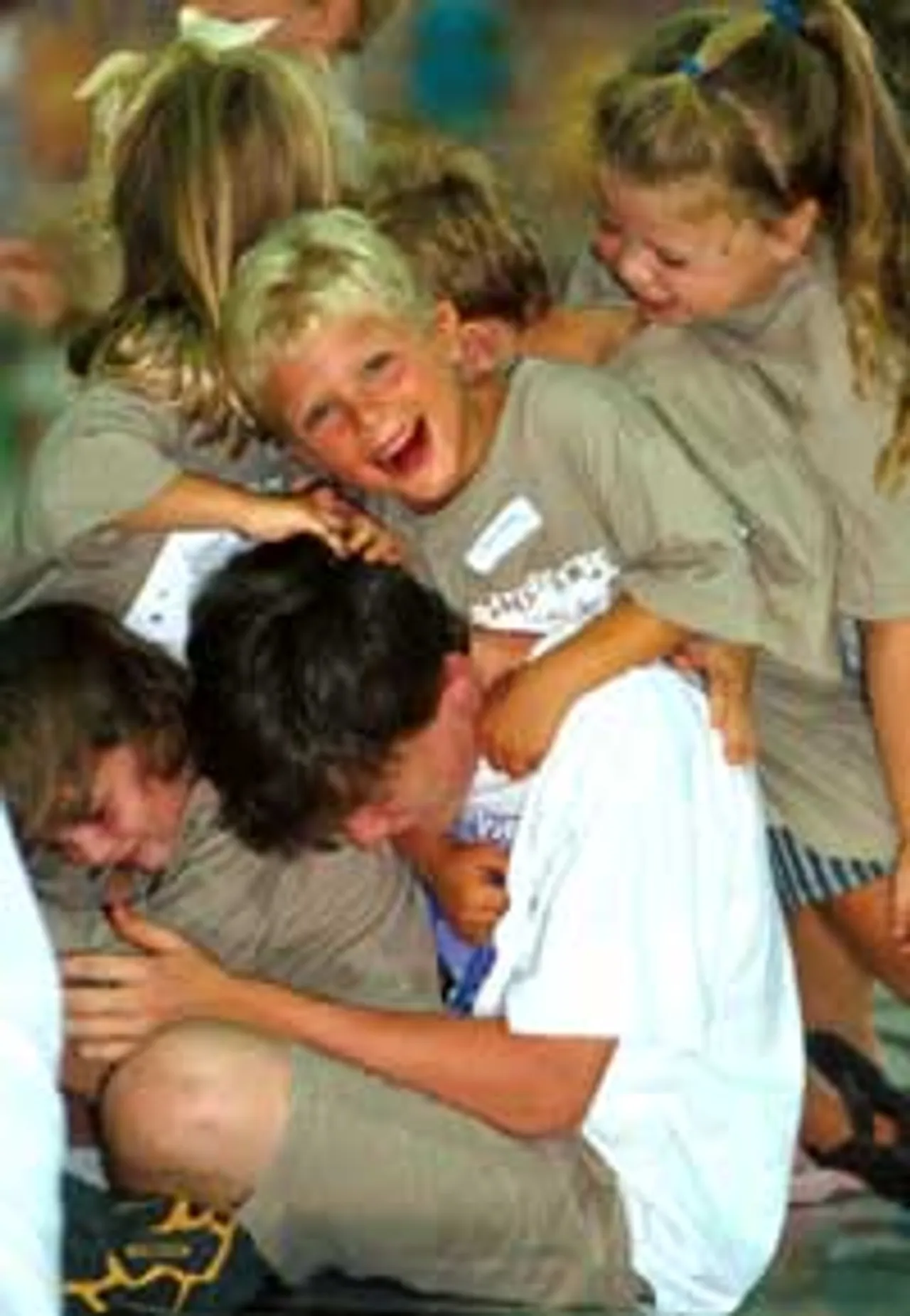 Delightascope campers take a break from morning classes to tackle their counselor.