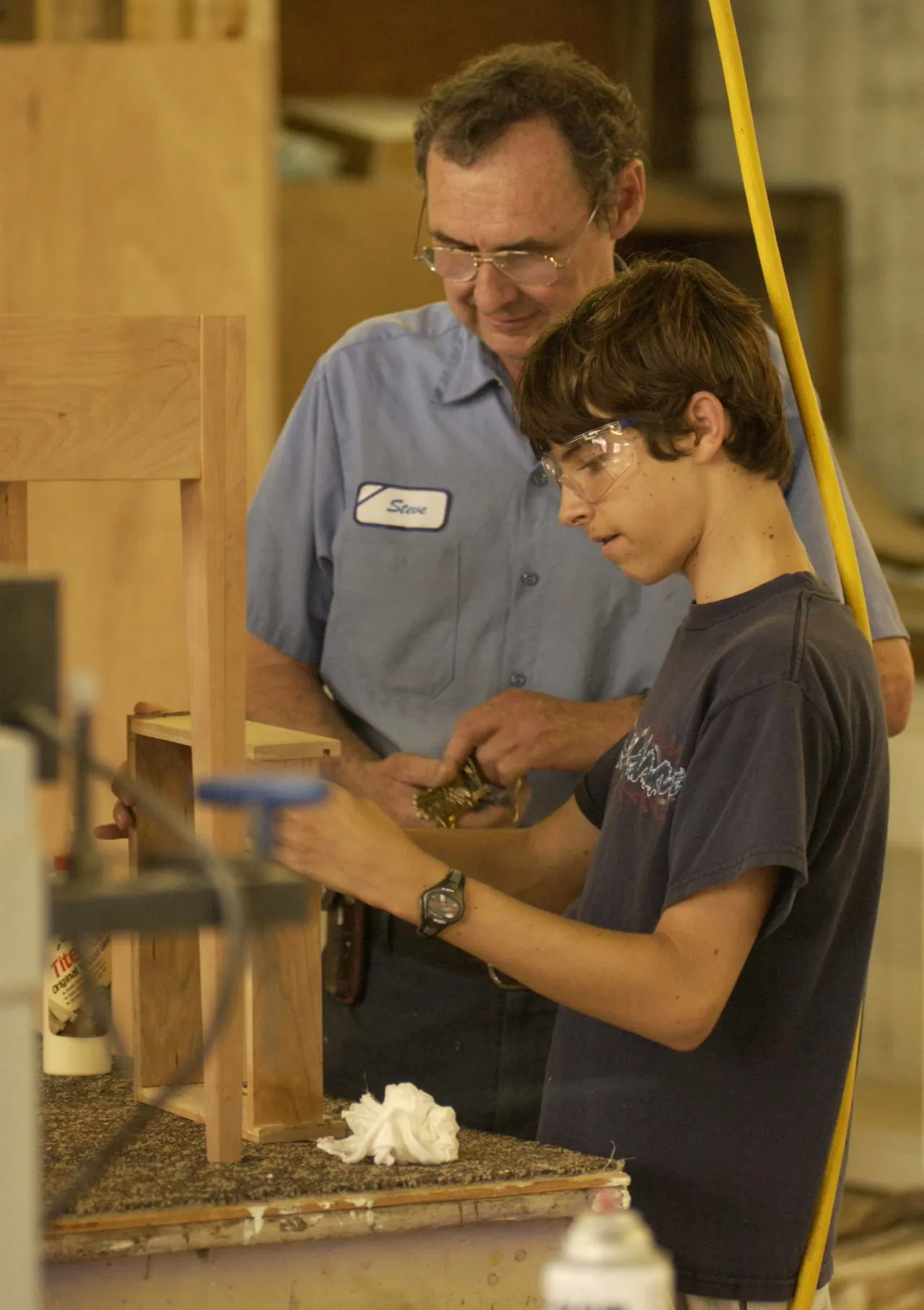 Woodworking Instructor Steve Herod looks on as freshman Brian Albury assembles a drawer.