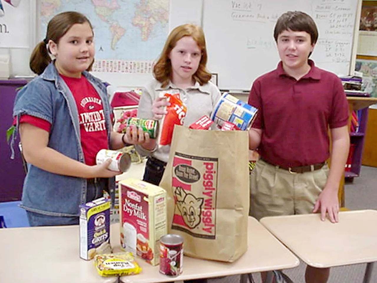 Sixth-grader Morgan Myers, seventh-grader Ashley Astin, and eighth-grader Kirk Riedling collect food for Rome Urban Ministries.