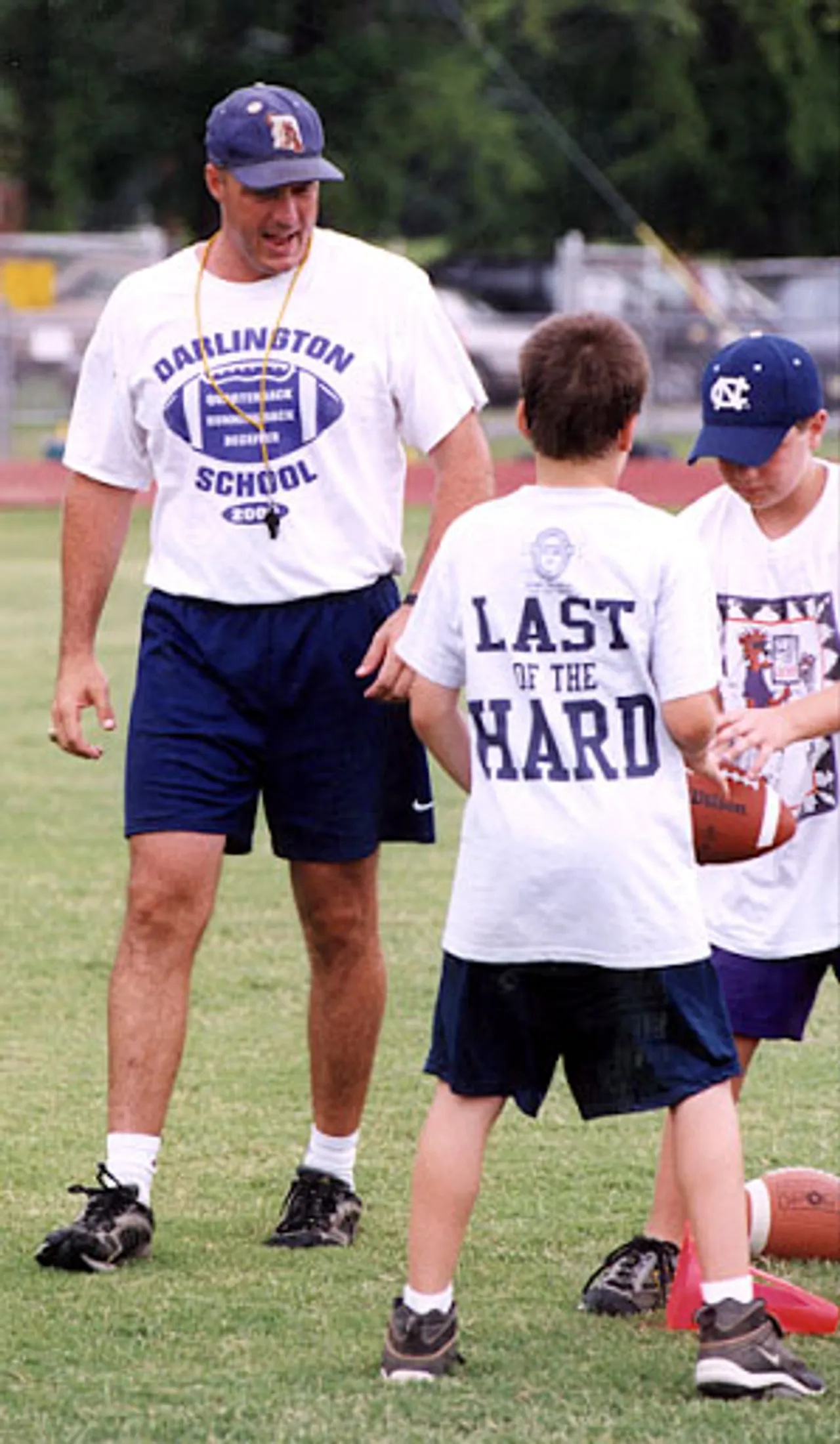 Coach Atha instructs his campers on how to handle a football.