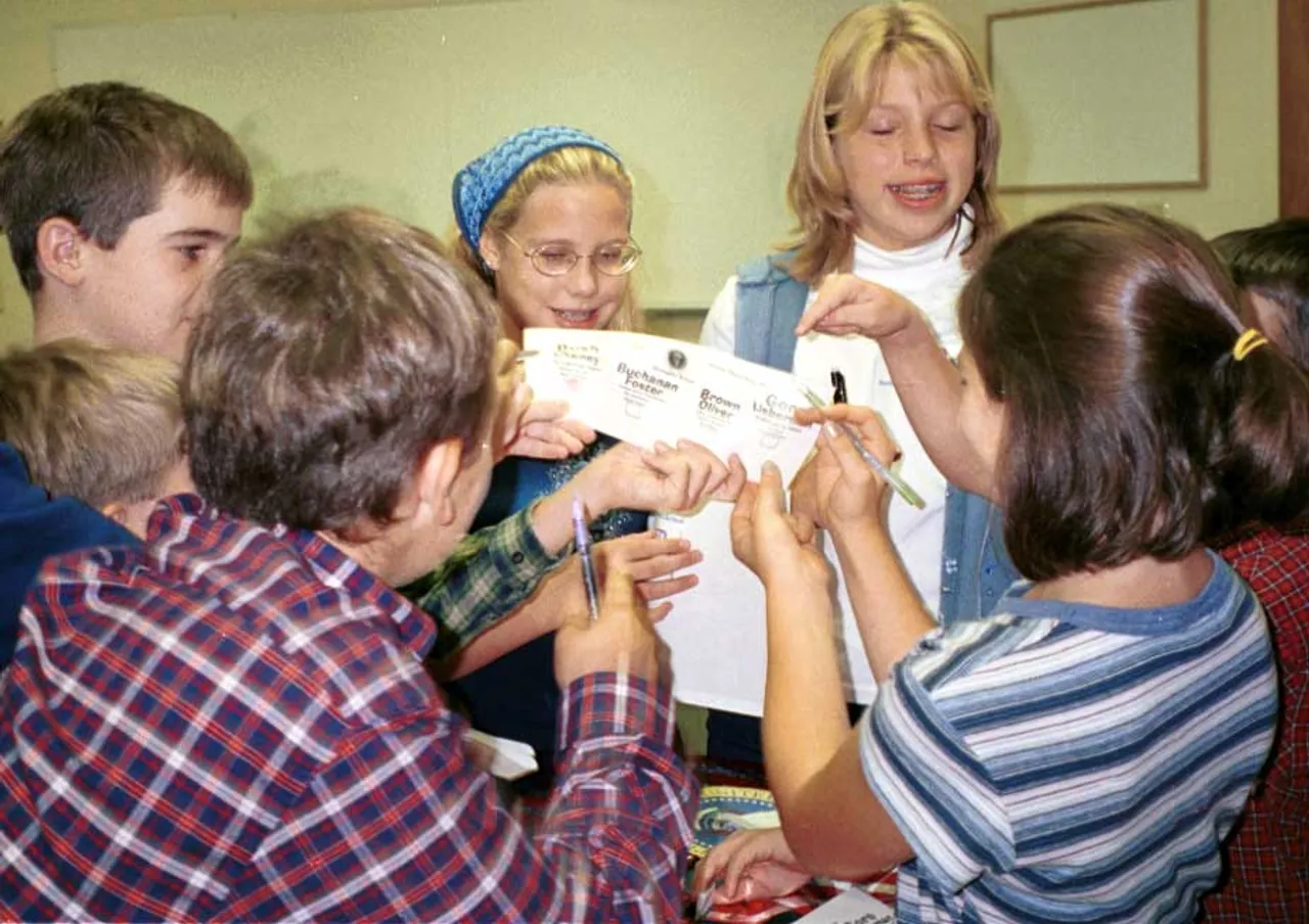 Middle Schoolers scramble for ballots during a mock election.