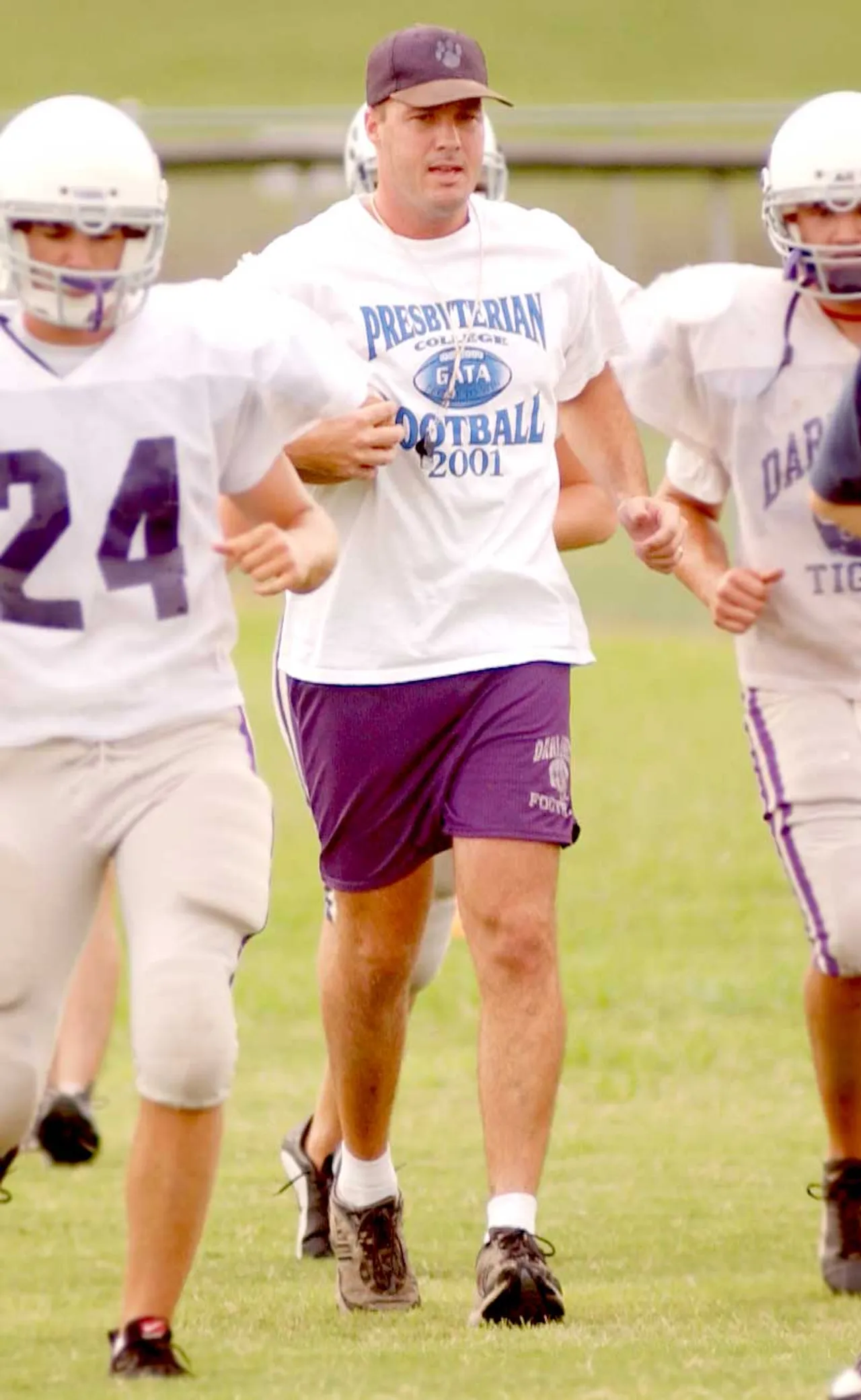Atha runs with his players during a pre-season practice.