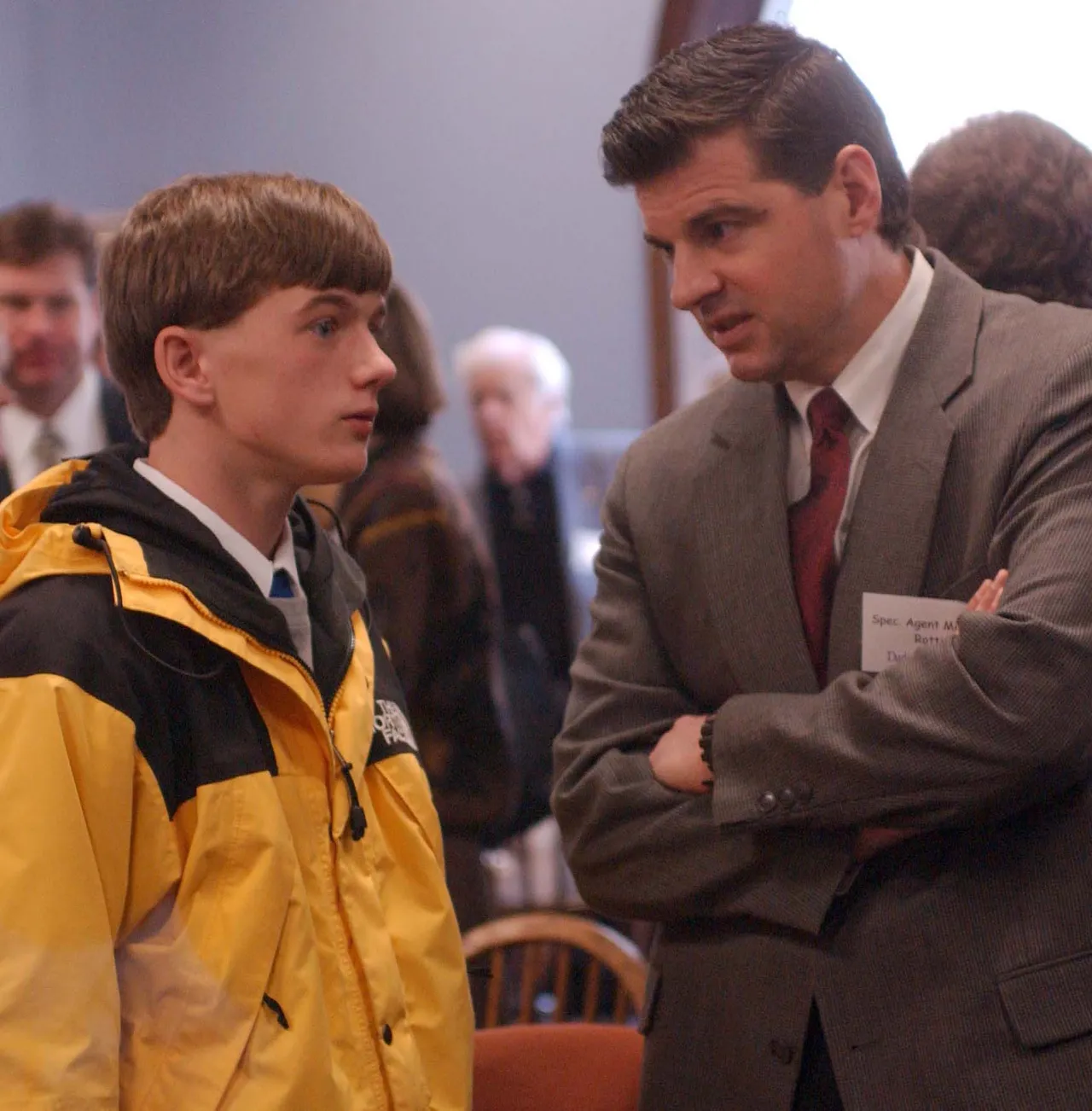 Michael Rotti, a special agent in law enforcement, talks with a student host during a reception held for the speakers.