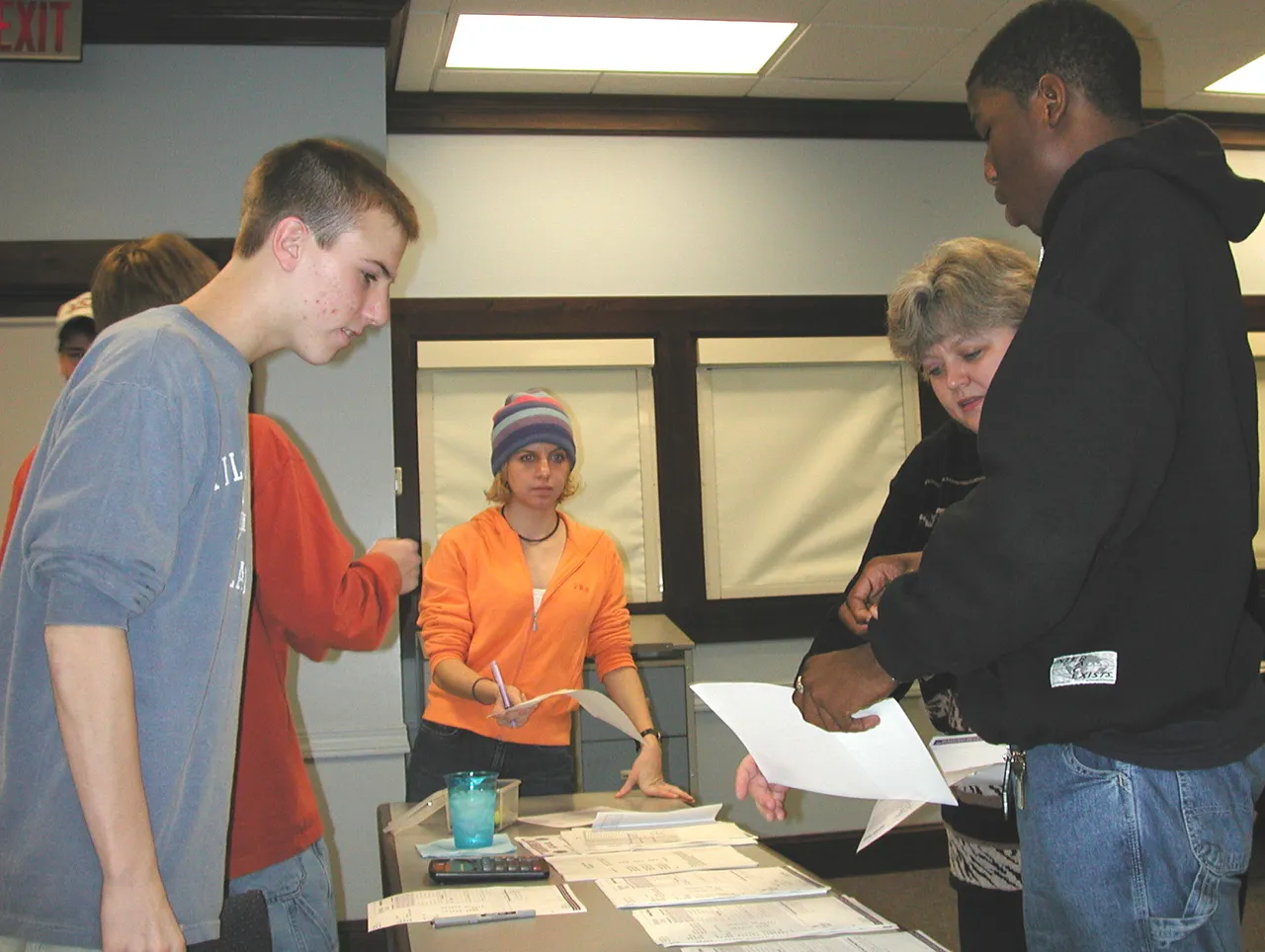 S.O.A.R. organizer Lisa Nichols (second from right) distributes phonathon sheets to students callers.
