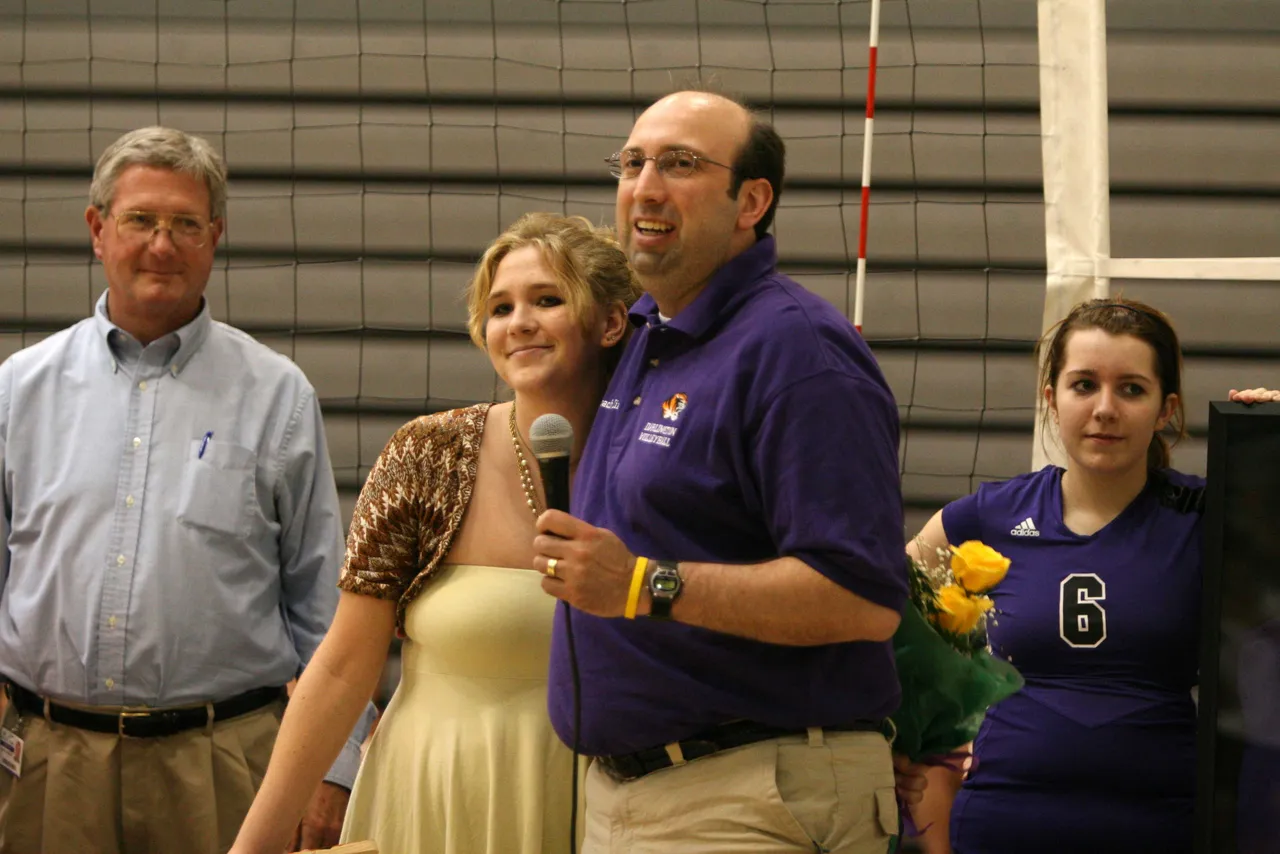 Alicia Wright ('07) hugs varsity volleyball head coach Jim Linos.