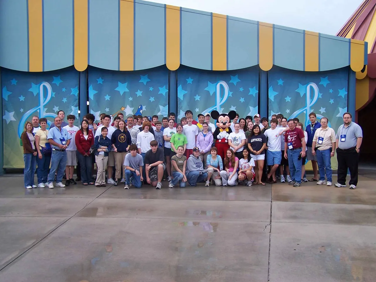 Band members pose with Mickey Mouse.