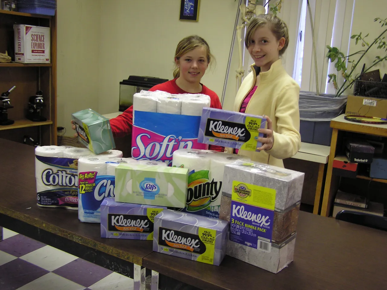 Sixth-graders Katy Rohani and Maggie Seckman collect and organize paper goods for the homeless shelter.