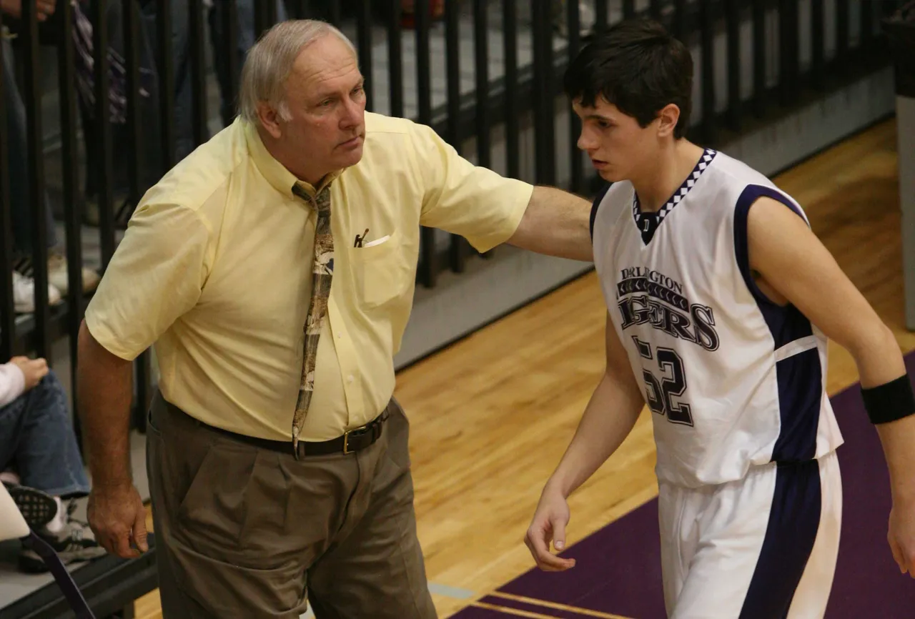 Van Es congratulates a player coming off the court during the first round of the state playoffs in 2005-06.