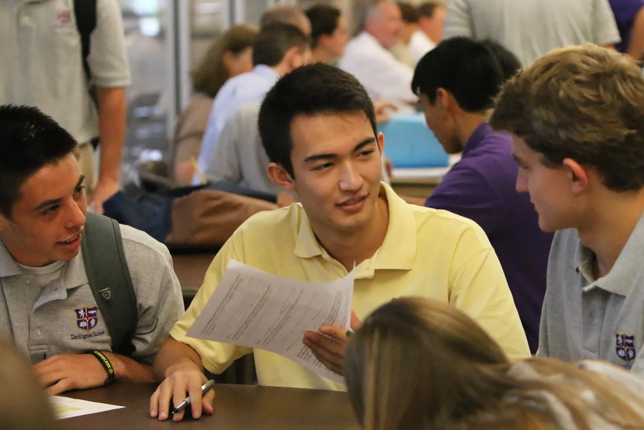 Seniors Kyle Tackeberry (left), Dylan Paracka and Charlie Shorey discuss the schedule of events for College Boot Camp.