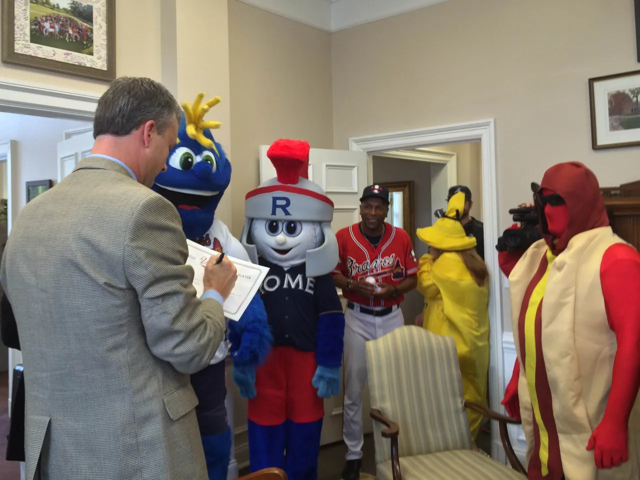 Head of School Brent Bell signs a one-day contract to play with the Rome Braves following a surprise "ambush" from team representatives in costume last month.