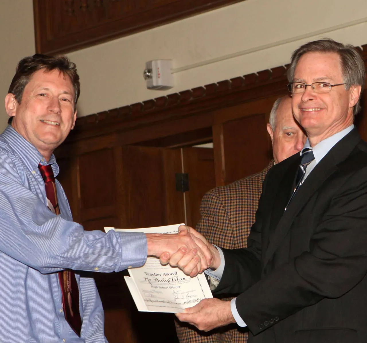 Al Hodge presents Phil Titus with the STAR Teacher certificate.