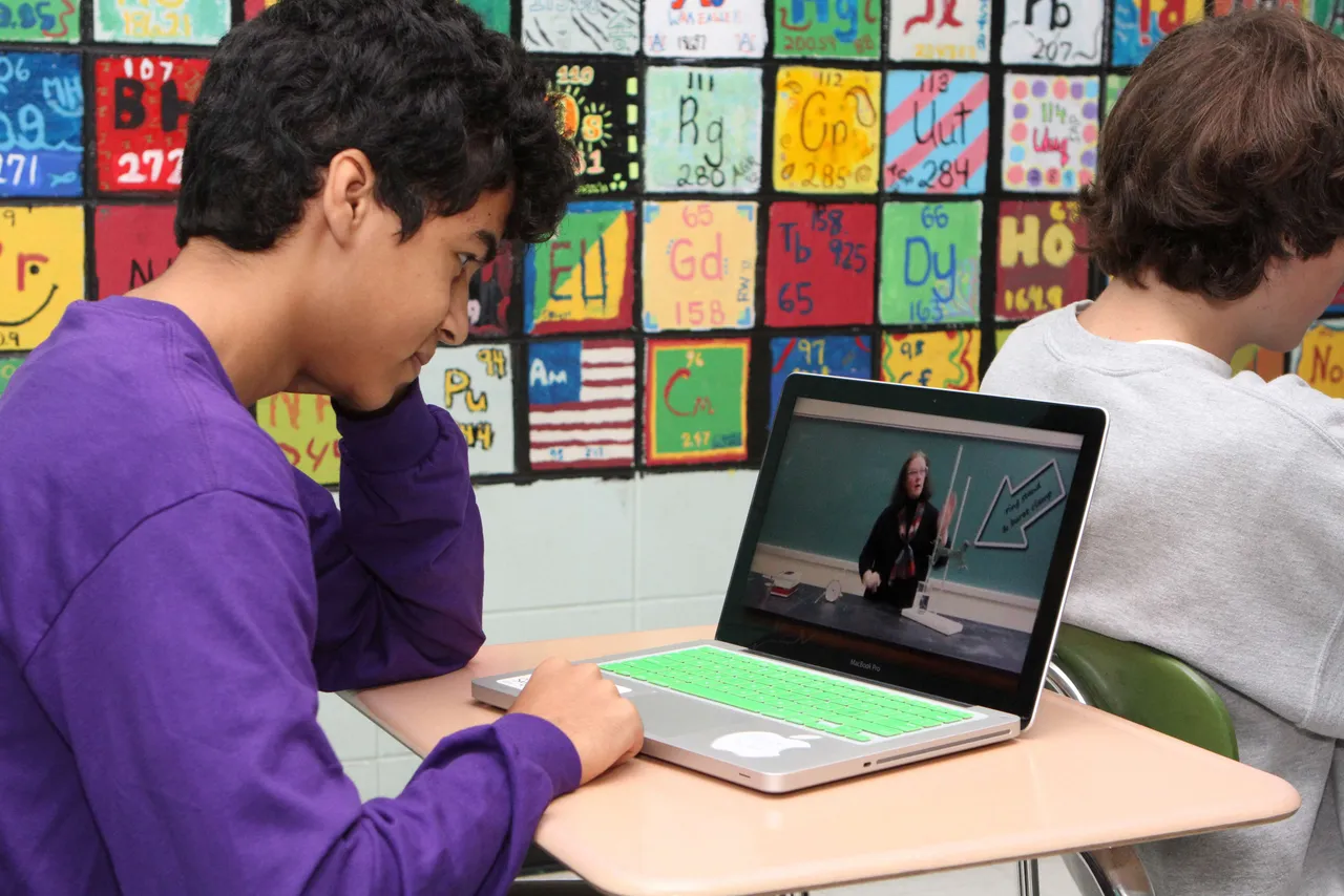 Sanjid Dewan (’14) reviews a video of his chemistry teacher, Julia Dodd, quickly before class. Mrs. Dodd is among several teachers at Darlington using the flipped classroom model, which allows students to view lectures before class time, thereby giving more time in the classroom to work on hands-on work like labs, projects or discussion. The idea is to let students take more responsibility for acquiring information on their own and use time with their teacher and classmates more effectively.