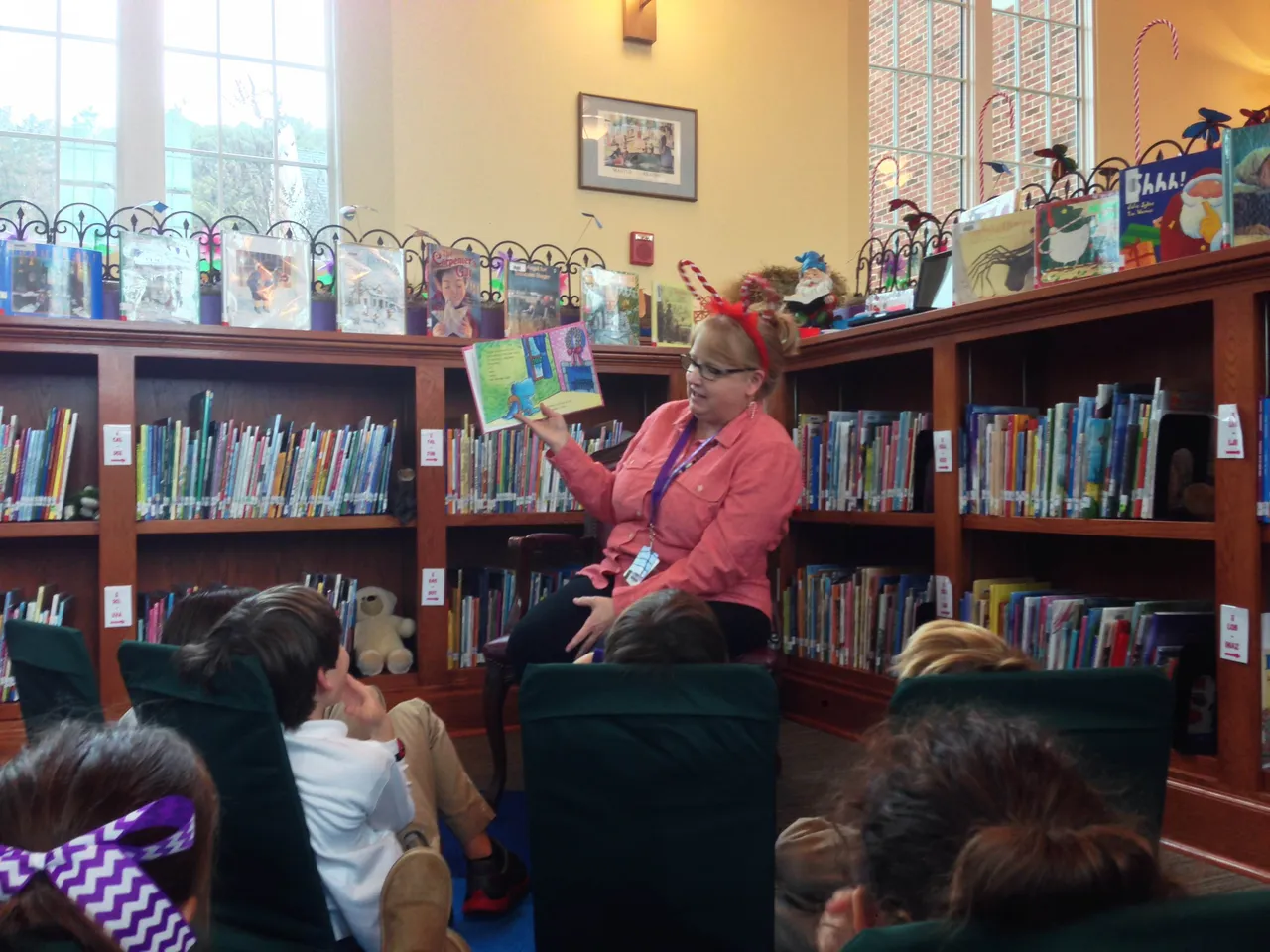 Mrs. Foster reads a story about a dragon at Christmastime to second-graders in the Secret Garden of the Lower School library.