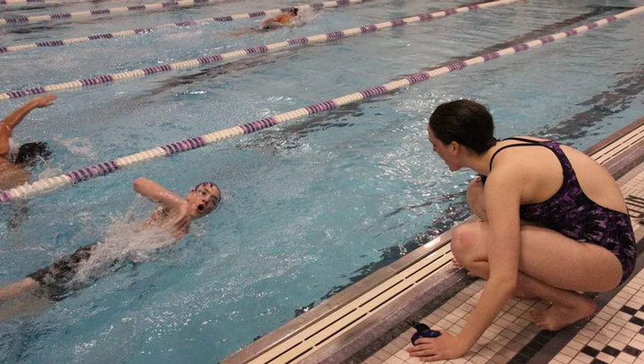 Junior Mary Margaret Wright (right) cheers on freshman Reid Blackmon in his 100 yard freestyle at Darlington School on Thursday, Jan. 8, 2015. (Photo credit: Sierra Campbell/Rome News-Tribune)