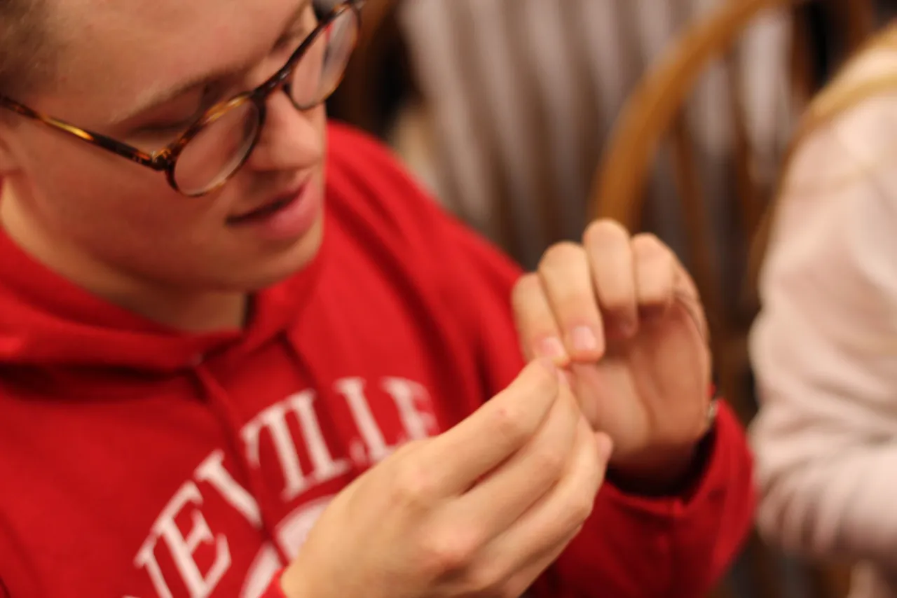Senior Adam Posey constructs an Arm Kandi bracelet to help with a Cancer Navigators fundraiser.