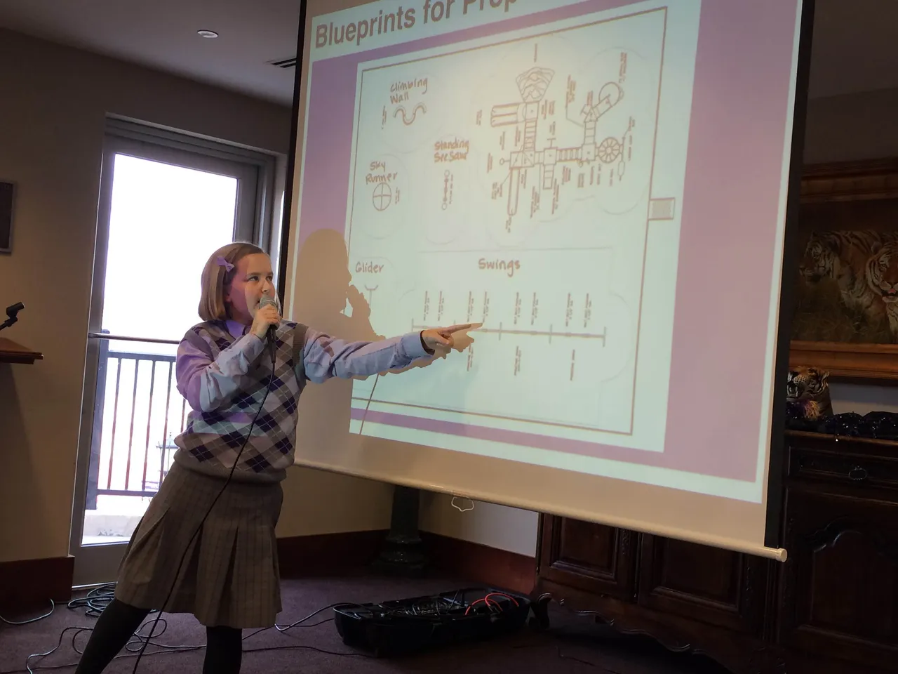 Third-grader Mary Blair Fuller points out different features on playground blueprints.