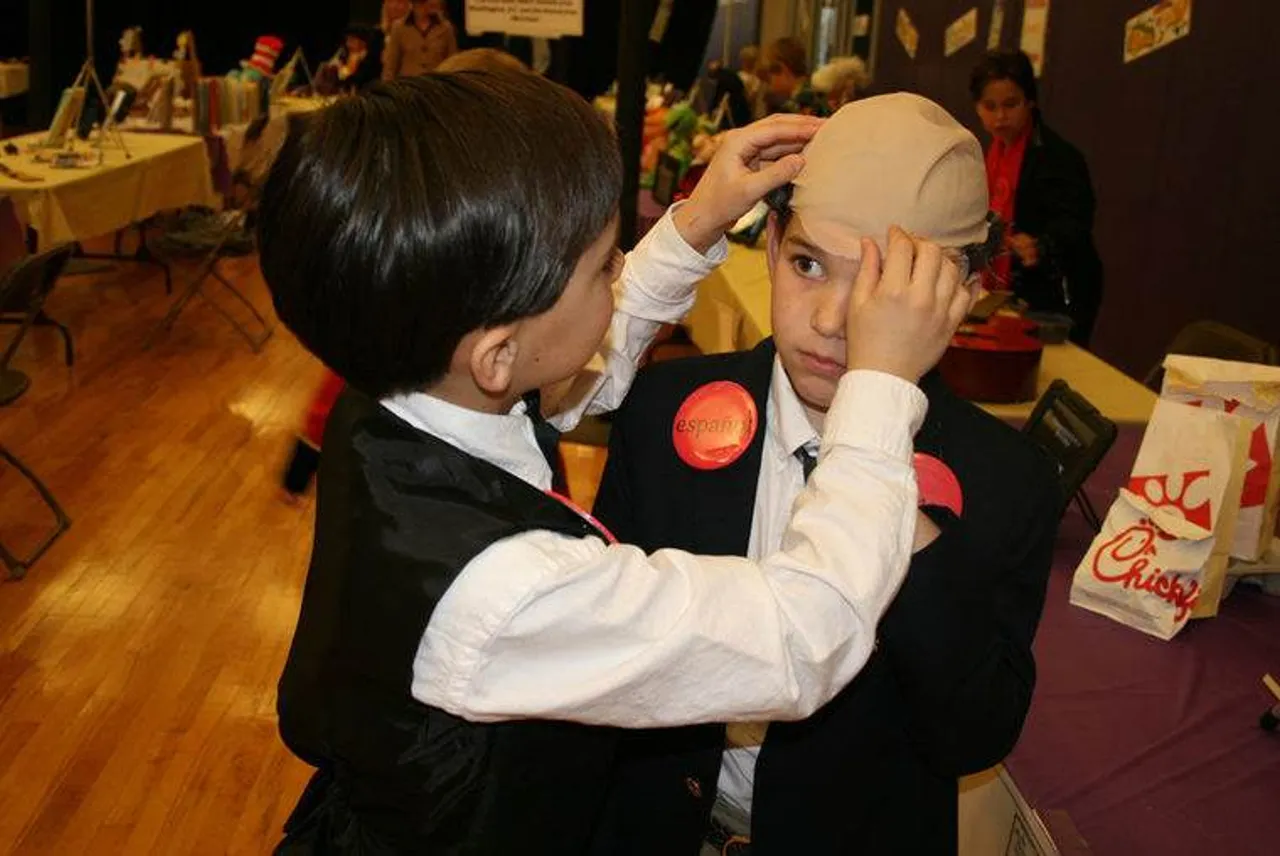 Tommy Cowan, who was portraying Thomas Edison, helps Gus Gandy as Truett Cathy straighten his bald cap during a short break at the Wax Museum at Darlington School. (Photo credit: Kristina Wilder / RN-T.com)