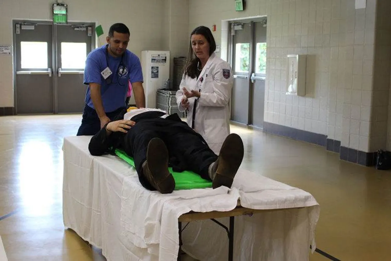 Gabriel Bird (left) and Carey Price, both volunteer nursing students, help out during the Darlington Prom Promise. Bird and Price acted as emergency room personnel dealing with a teenaged car crash victim. (Photo credit: Kristina Wilder / RN-T.com)