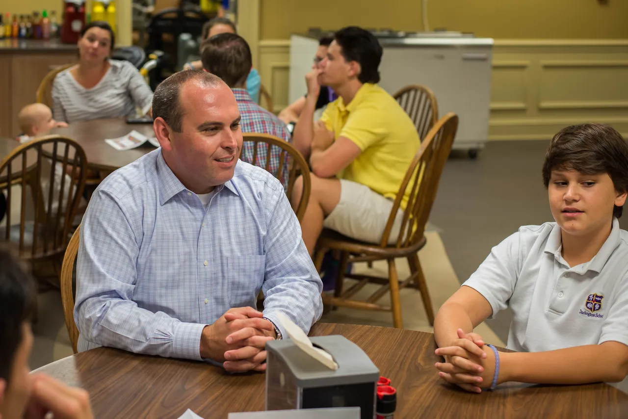 Upper School Director Matt Peer visits with students during dinner.
