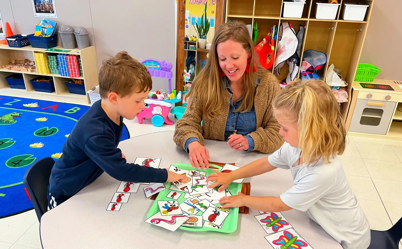 Mason Prep teacher working with two students on a hands-on learning project