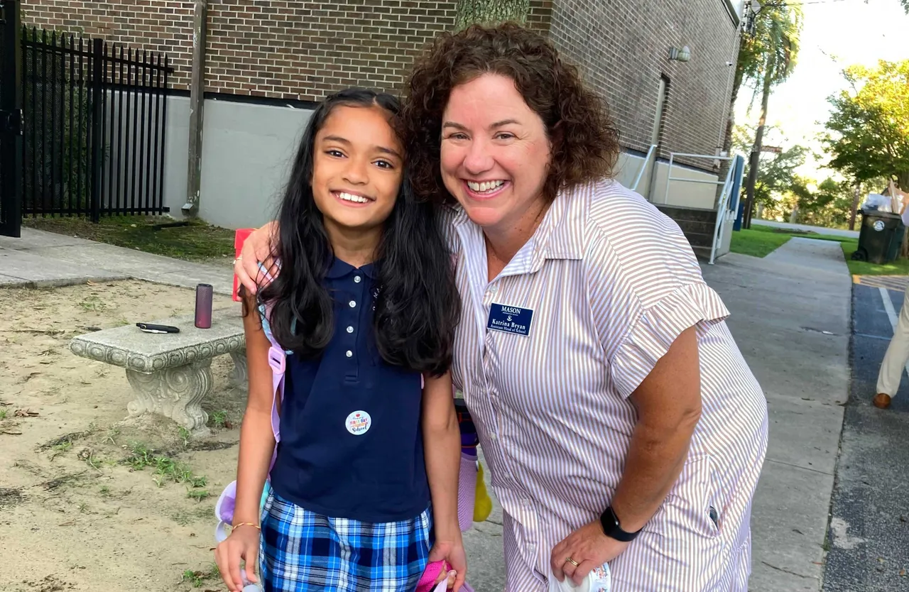 Masoin Prep Teacher standing by young student